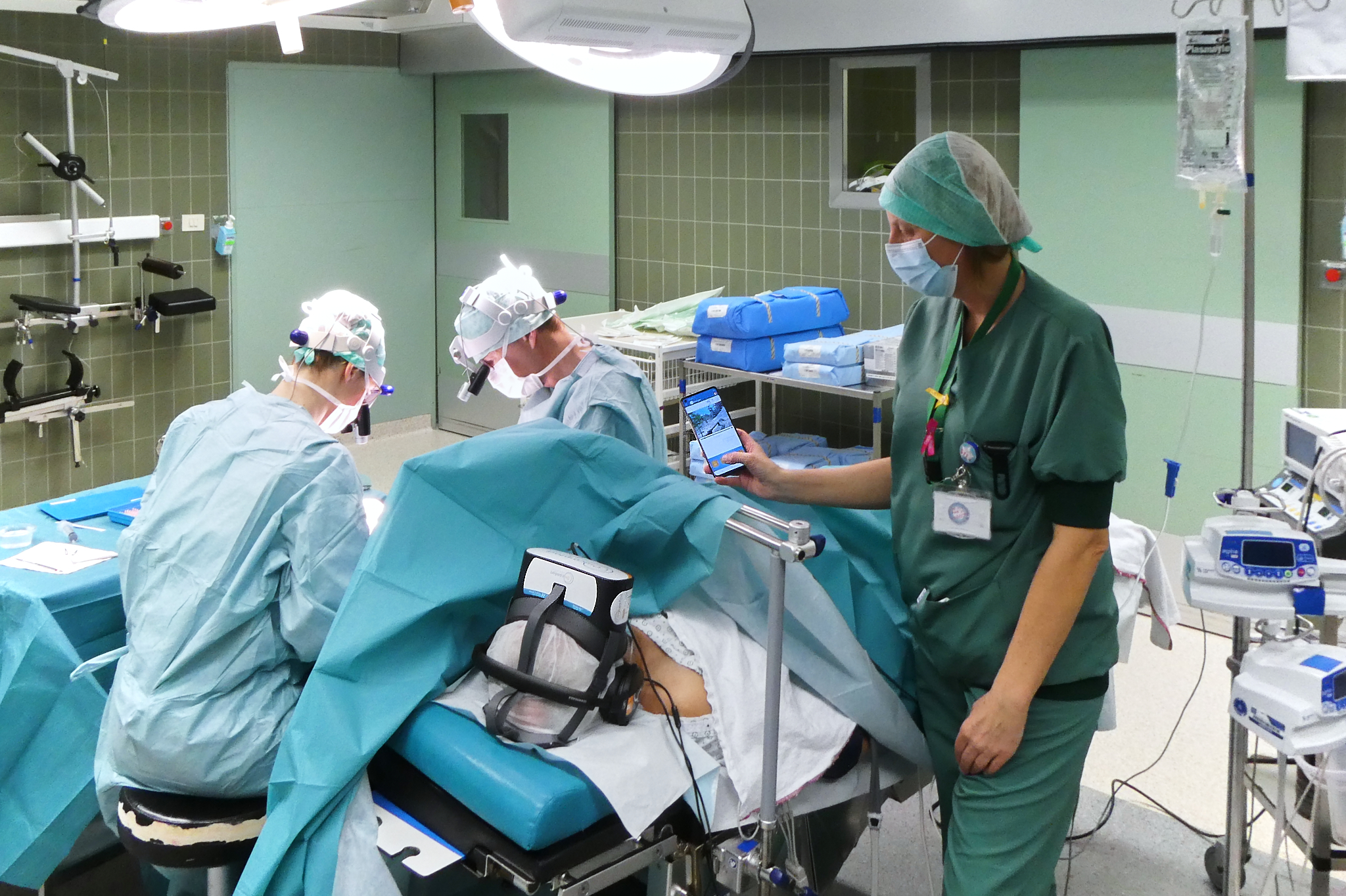 patient with VR glasses, doctors and a nurse in a operating room